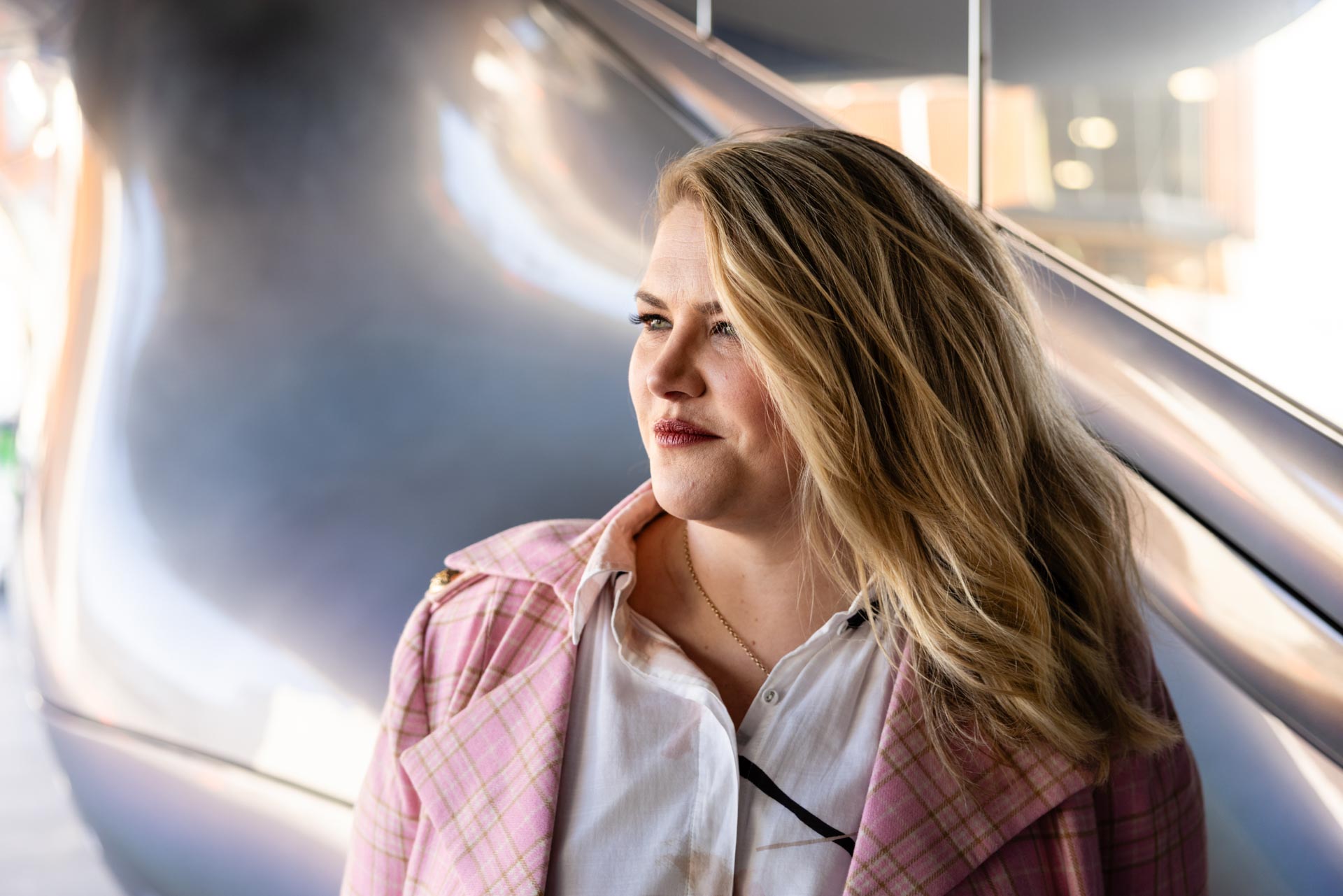 Portrait of Camille beside a polished metal wall