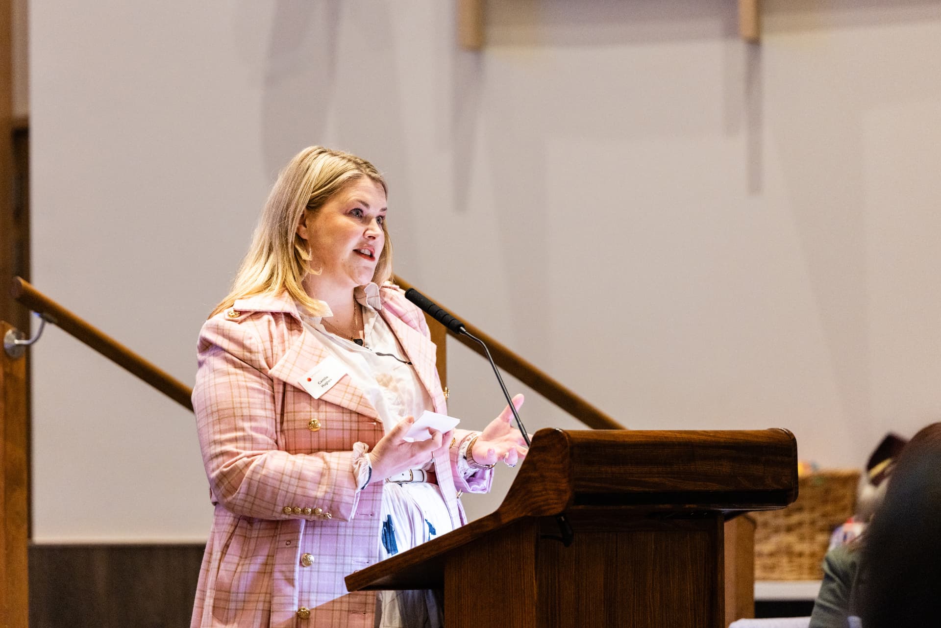 Camille Hughes presenting at a lectern with a microphone