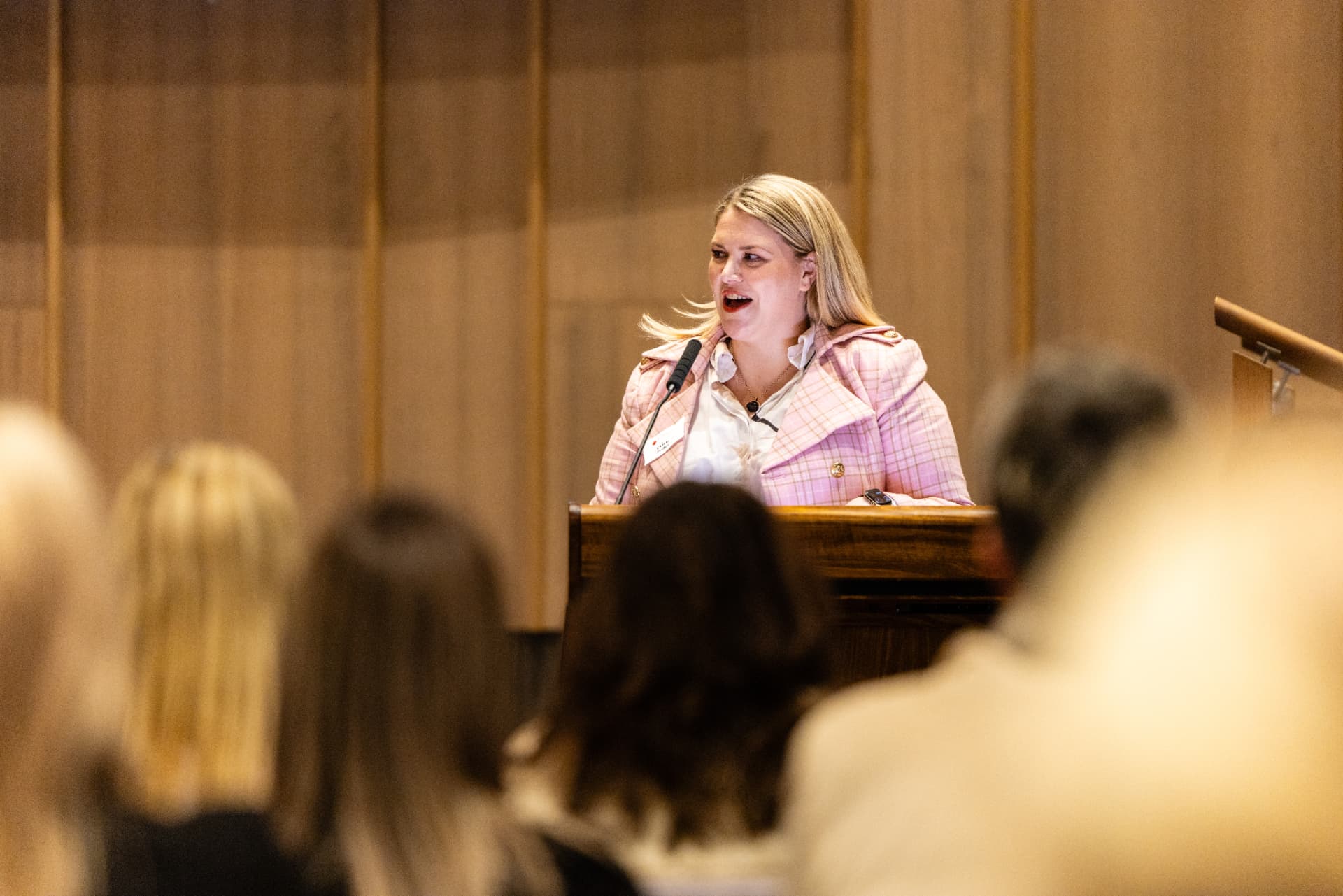 Camille speaking on stage to an audience
