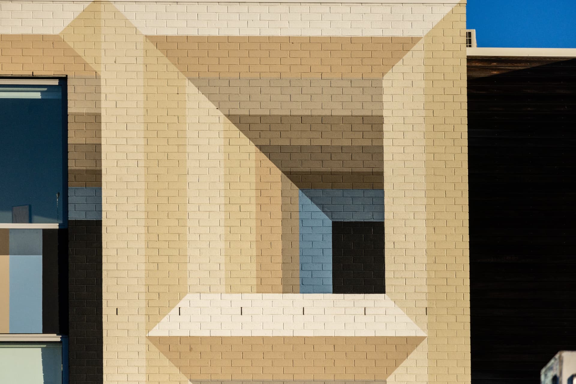 A sand-coloured brick wall with a recessed square niche